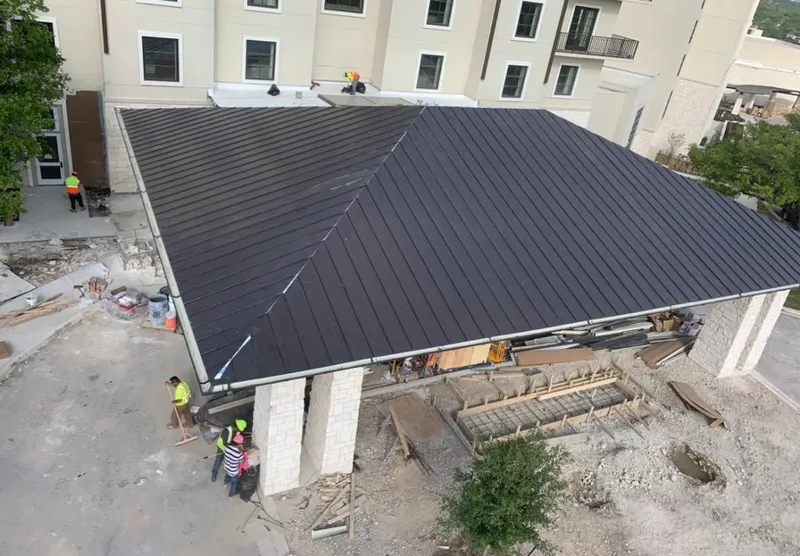 Metal roofing installation team working on a commercial building in Bristol